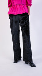 woman wearing VAAI elasticated waist black velvet trouser with gold cross stitch