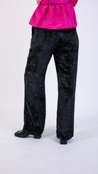 woman wearing VAAI elasticated waist black velvet trouser with gold cross stitch