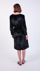 woman wearing VAAI black velvet dress with gold embroidery 