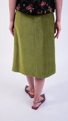 Woman wearing scallop detail green velvet skirt