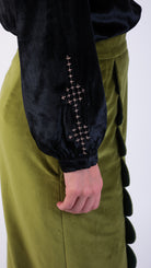 Woman wearing scallop detail green velvet skirt