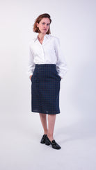 Woman wearing scallop detail checked navy wool skirt