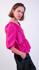 woman wearing VAAI pink silk peplum party top