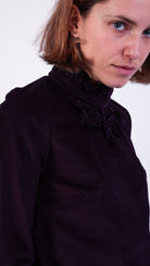 woman wearing VAAI aubergine corduroy ruffle top