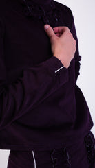 woman wearing VAAI aubergine corduroy ruffle top