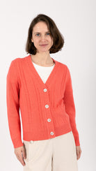 woman wearing VAAI coral cable knit cardigan