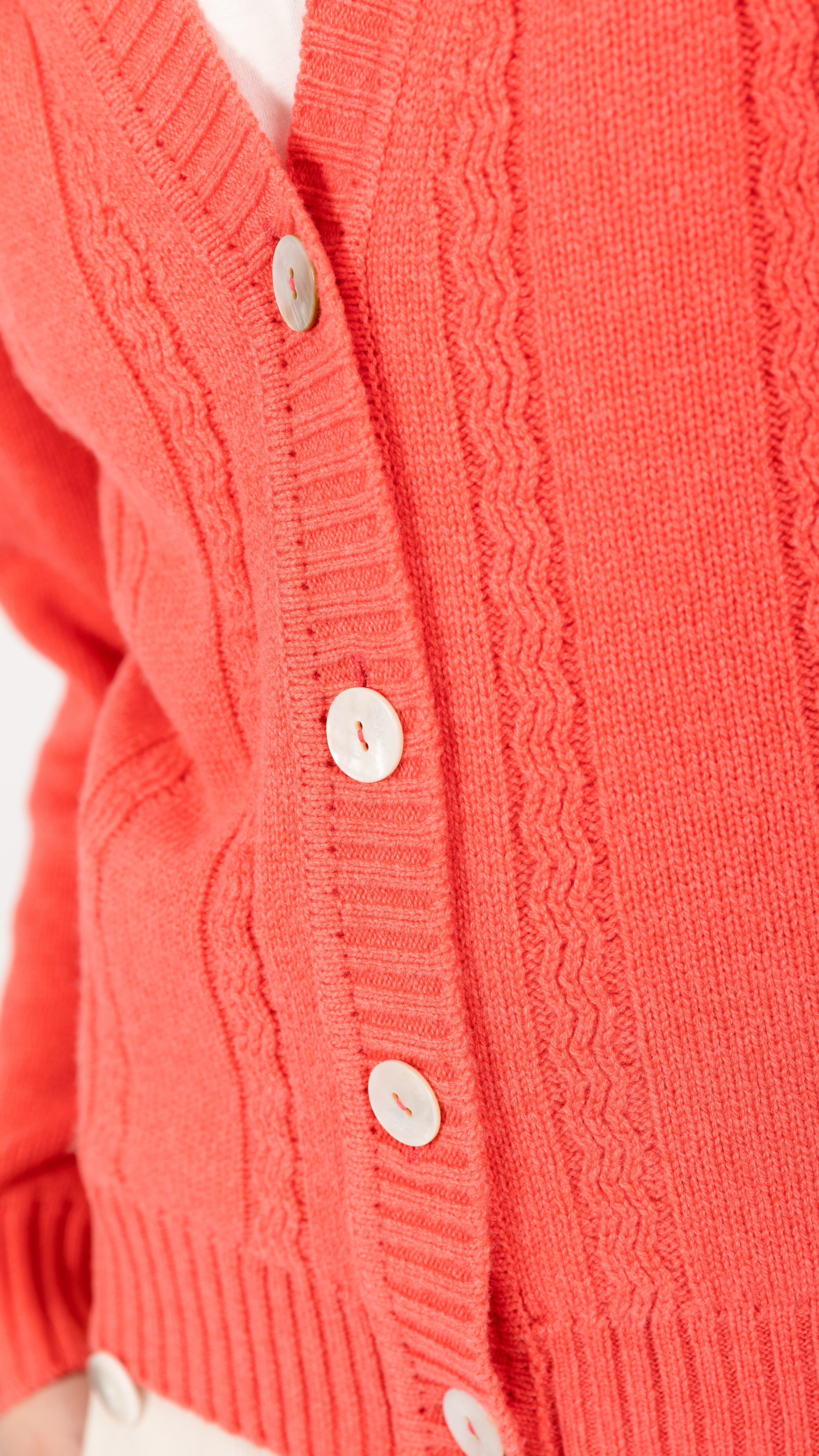 woman wearing VAAI coral cable knit cardigan