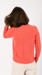 woman wearing VAAI coral cable knit cardigan