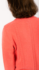 woman wearing VAAI coral cable knit cardigan