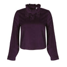 woman wearing VAAI aubergine corduroy ruffle top